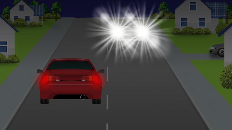 What should a driver do if dazzled by the lights of an oncoming vehicle?